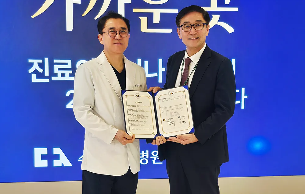 본율한의원 대표원장과 수원 덕산병원 관계자가 협약서를 들고 있는 모습