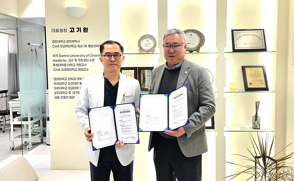 본율한의원 대표원장과 경기도기업경제인협회 관계자가 상호 협력 협약서를 들고 있는 모습